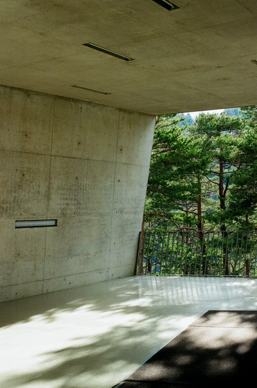 a building that has the top of it opened and is in front of a forest