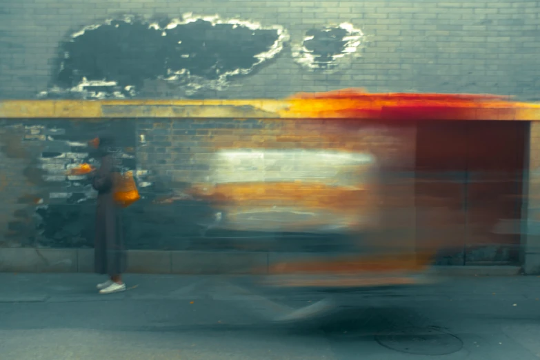 a blurry po of a man standing next to a bus stop