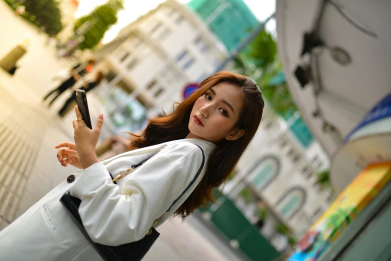 a woman in a white jacket is taking a selfie with her phone