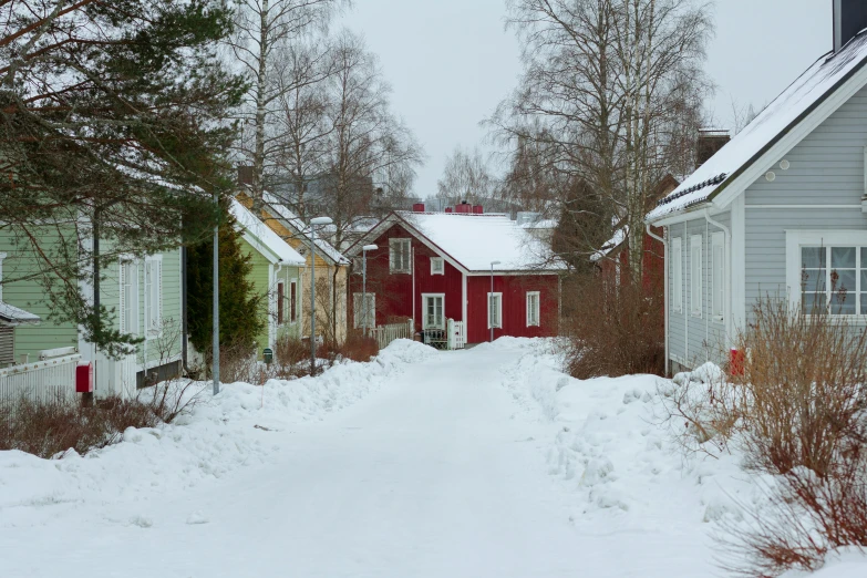 small red houses along a small road covered in snow