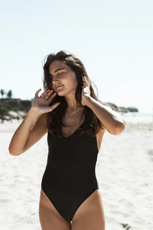 a beautiful woman in a bikini standing on top of a beach