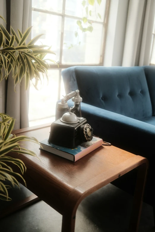 a blue sofa and a table with an old phone sitting on it