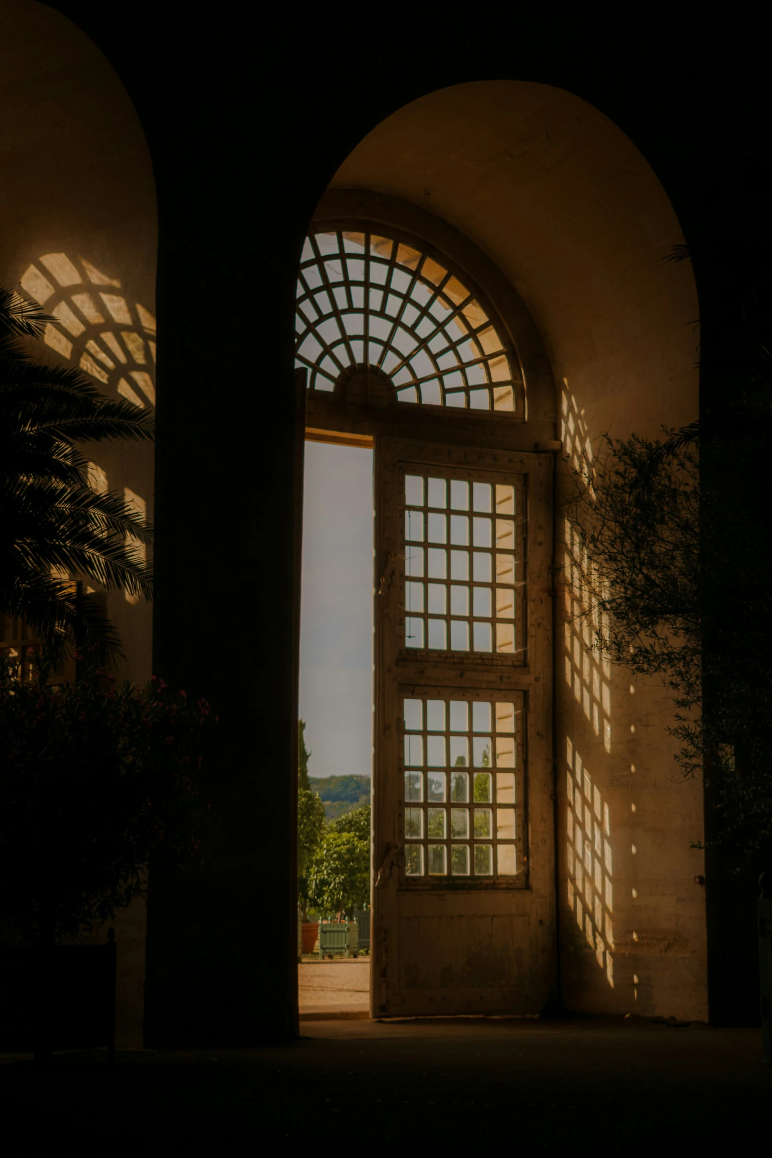 an open door in a building, looking out onto a garden