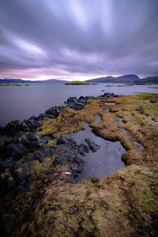 the shore is covered in mossy rocks