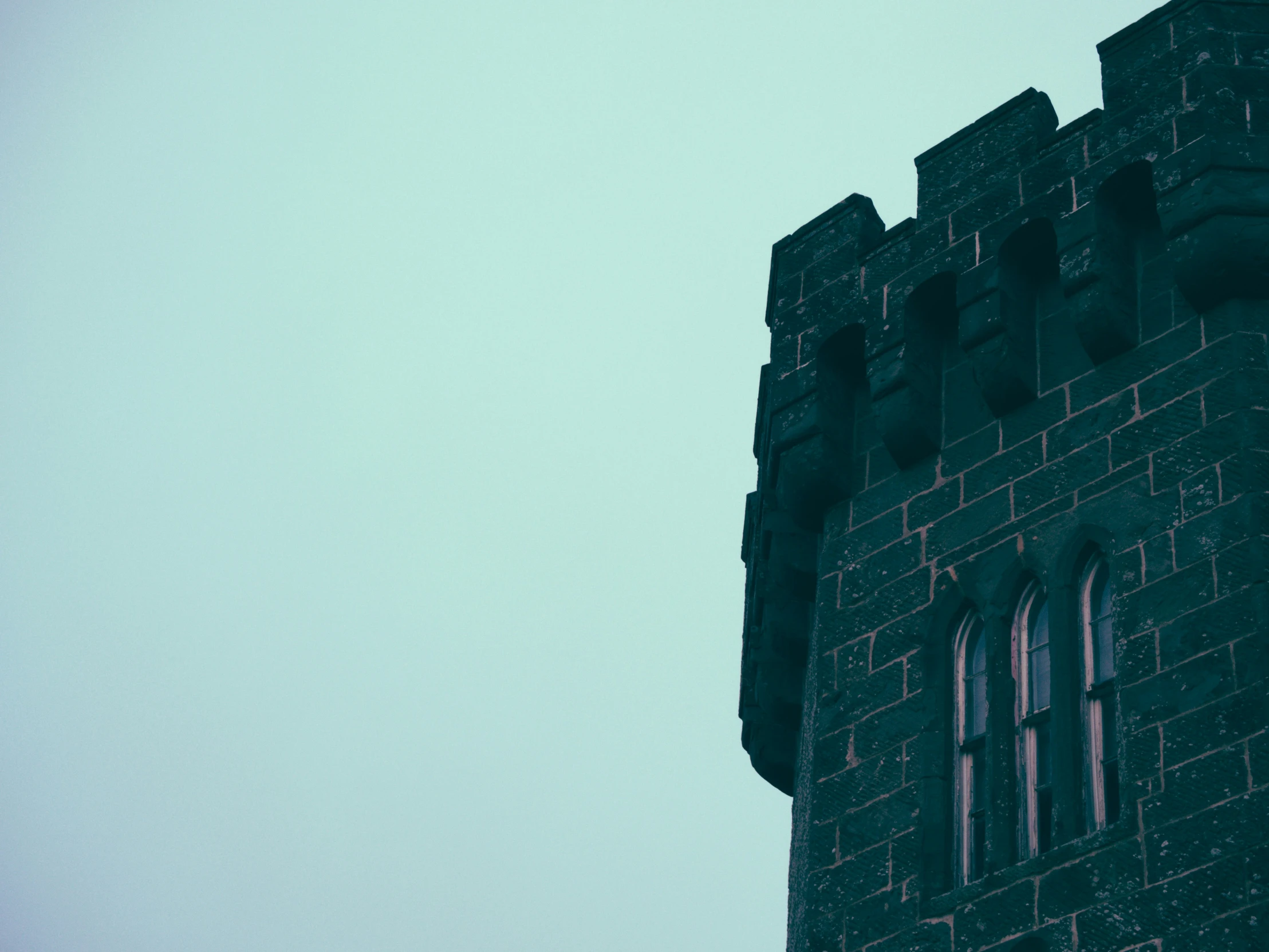 a large stone tower next to a very tall building