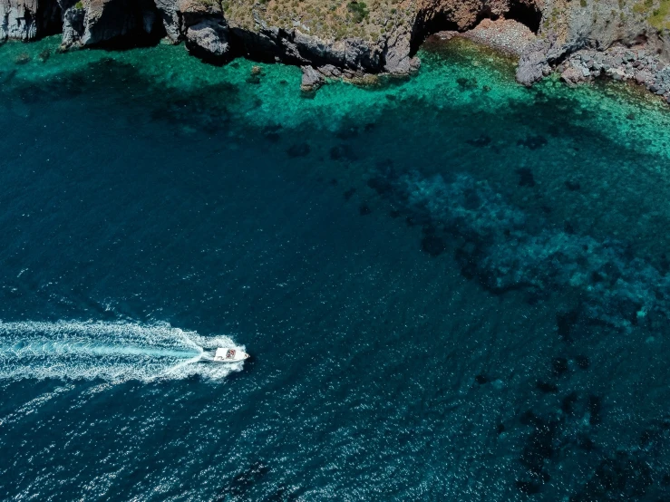 an aerial view of some water with a boat on the water