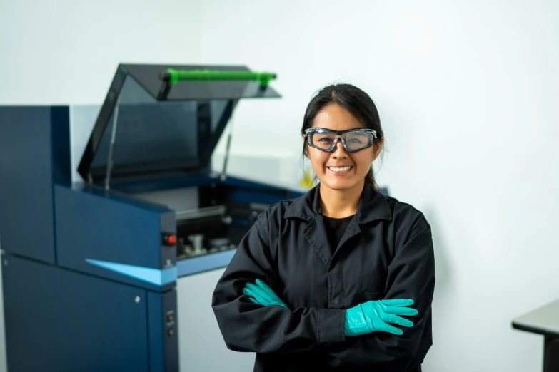 a woman with goggles is standing next to an empty screen printer