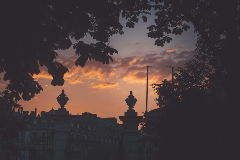 the sun sets over buildings near the city