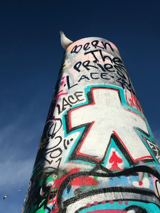 graffiti on a tall metal structure against a blue sky