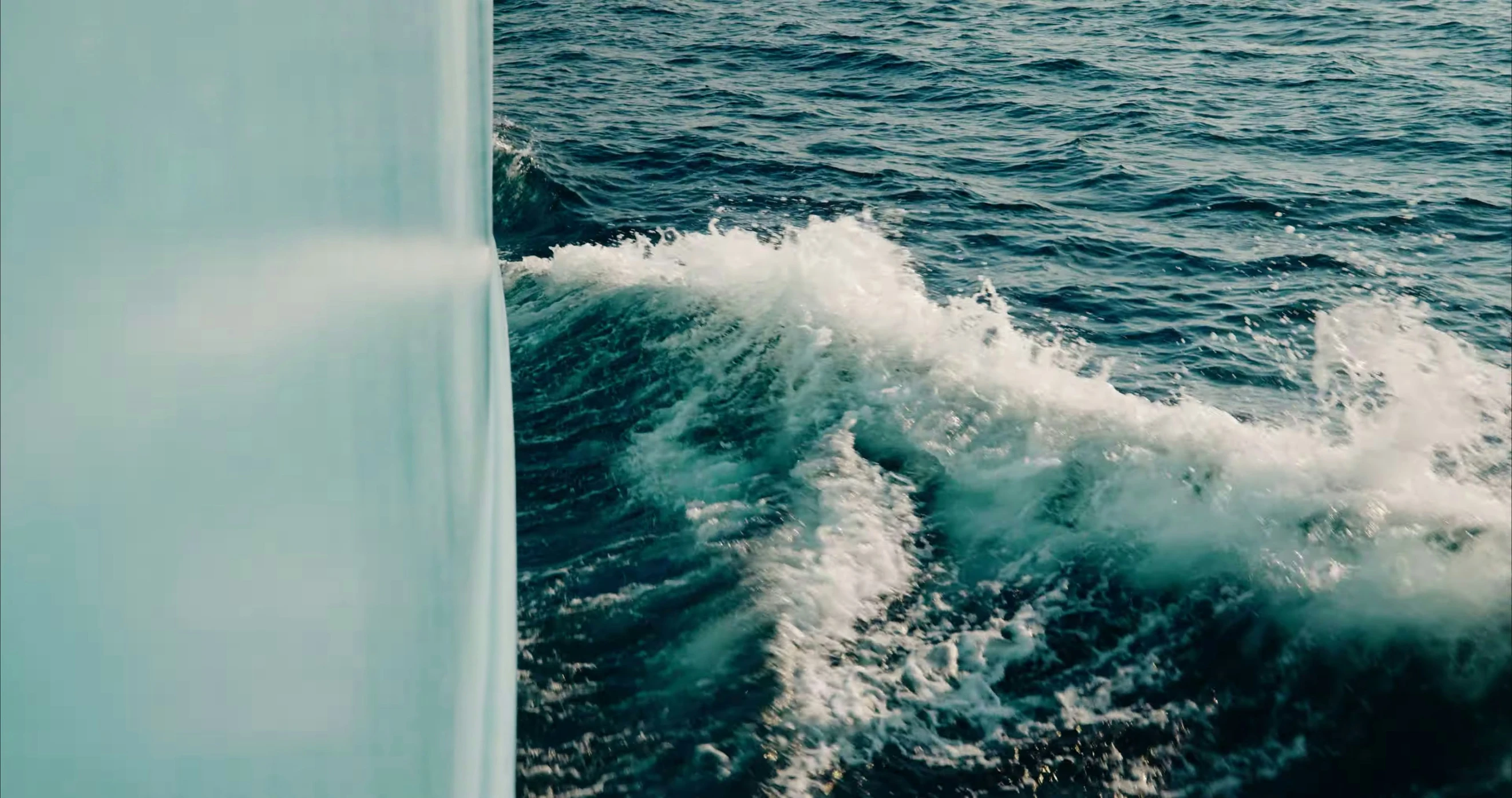 the back end of a boat with water crashing