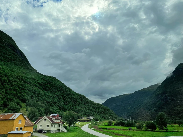 a mountain road leads to houses in the valley