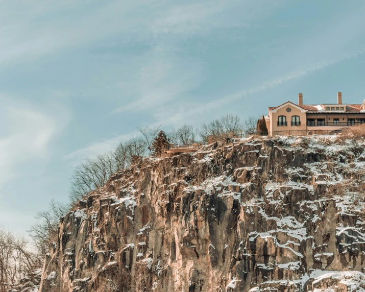 the mountains have snow on them, and there is a house on top