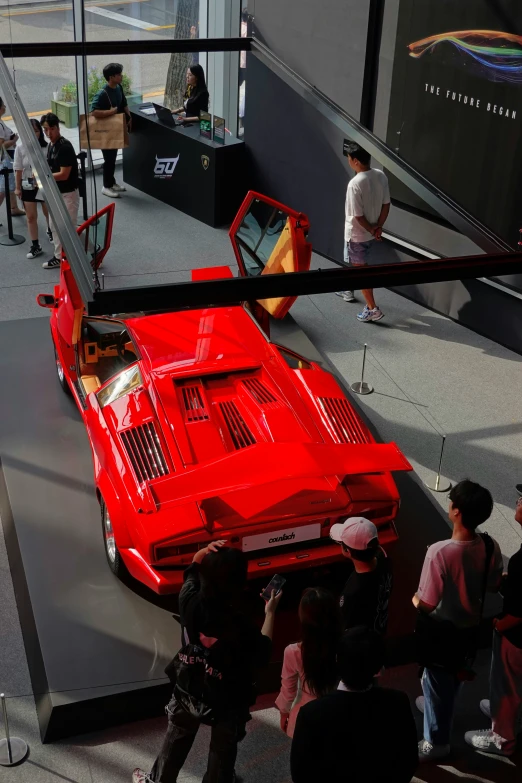 a red car on display at an automobile show