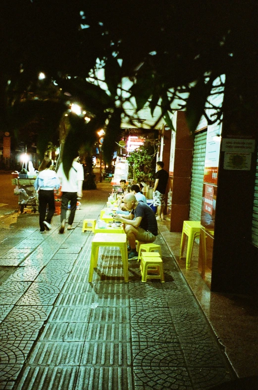 a group of people sitting on top of benches in front of a store