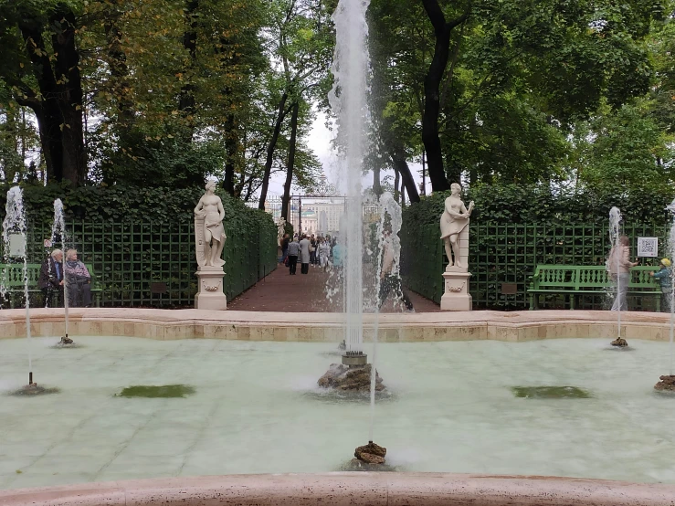 a fountain and some statues on top of a fountain