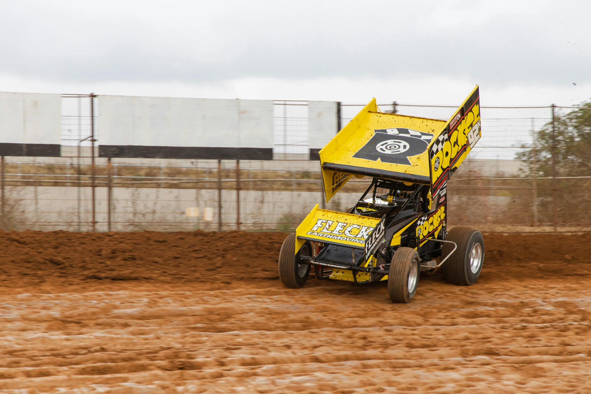 a big yellow vehicle is driving through a dirt course