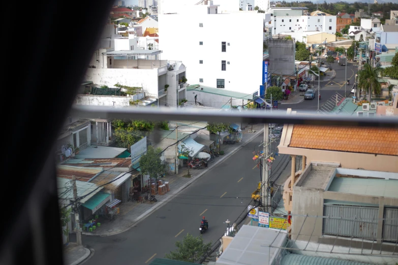 a view out the window of a building looking at buildings and cars