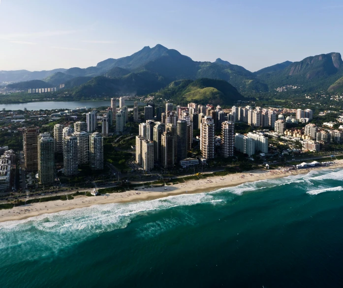 a long beach on the edge of some mountains and a large city