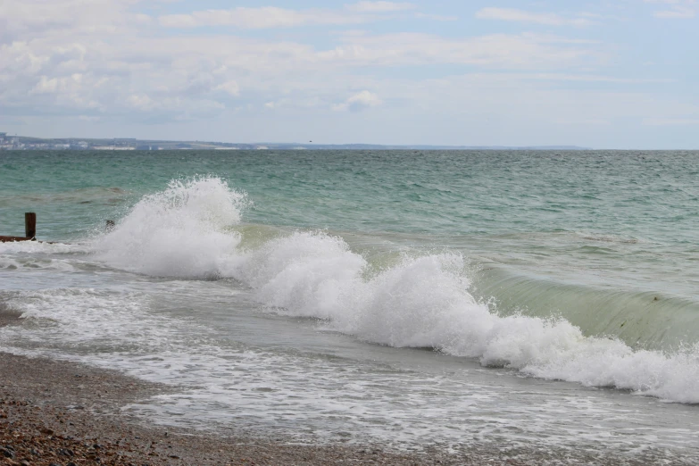 some water waves and white sand on a beach