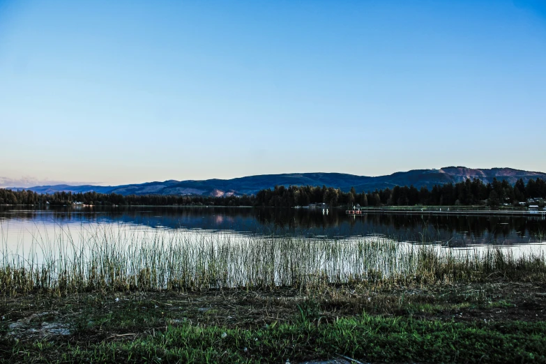 a view of a mountain lake, the sun is setting