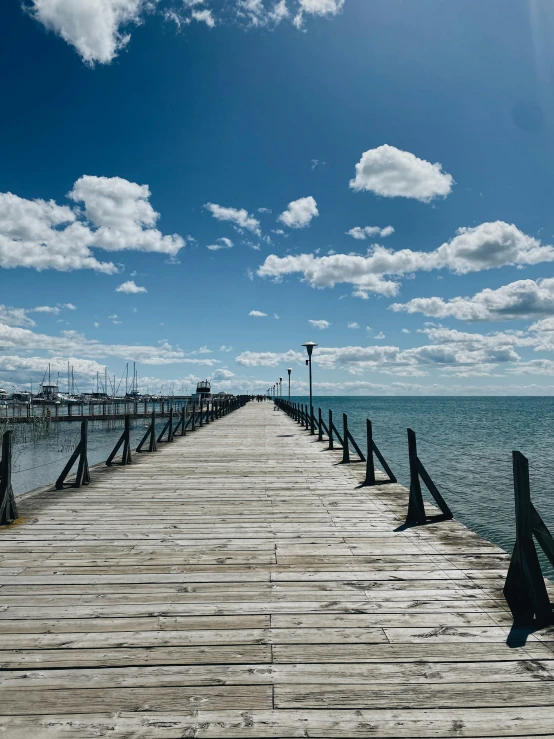 a pier extending into the ocean with a bright blue sky