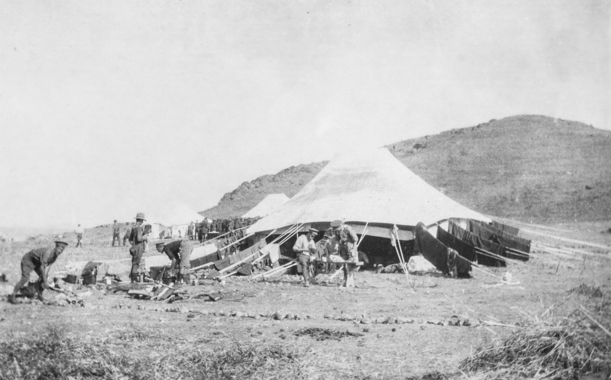 people and horses in front of an old fashioned tent