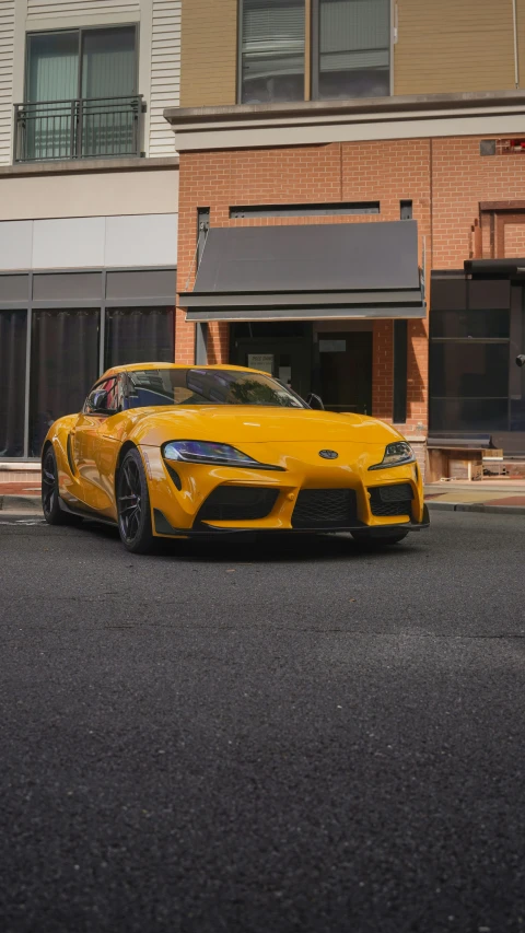 a sports car on the street in front of a building