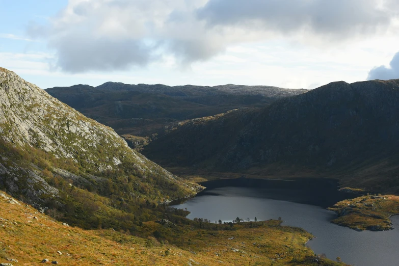 a rocky hillside with a body of water below it