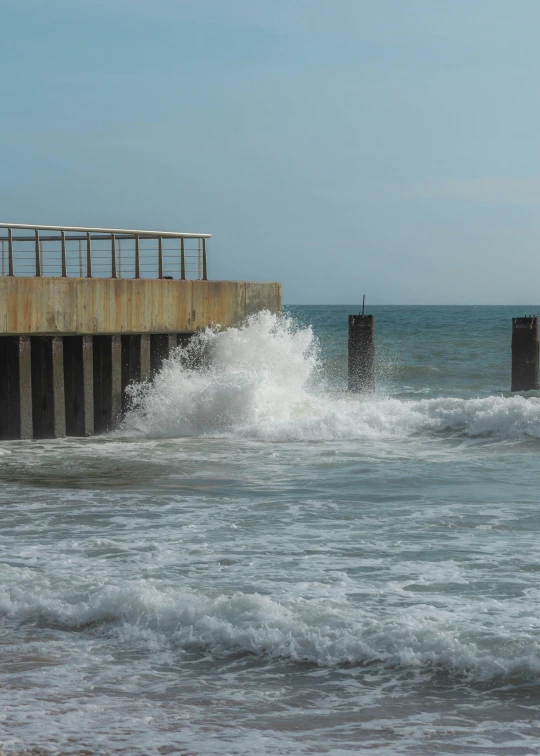 two small wooden posts with railings next to the ocean