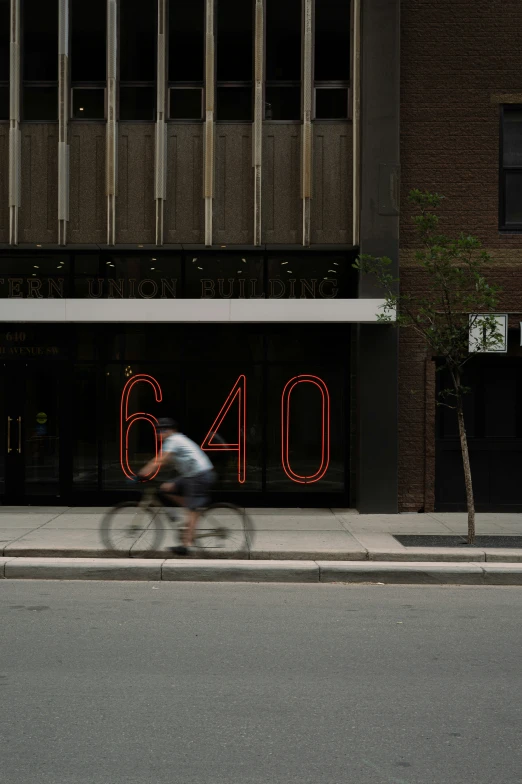 a bicycle rider going by a building decorated with lights