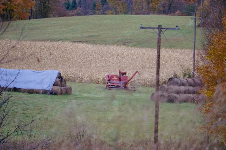 an image of tractor moving hay in field