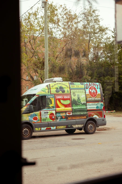 an automobile van with different advertising stickers painted on the side of it