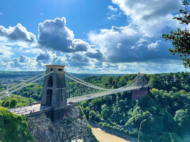 a very tall tower bridge over a lush green forest