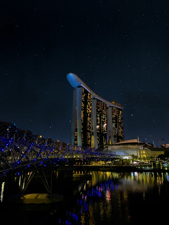 a city at night with skyscrs lit up and water in front