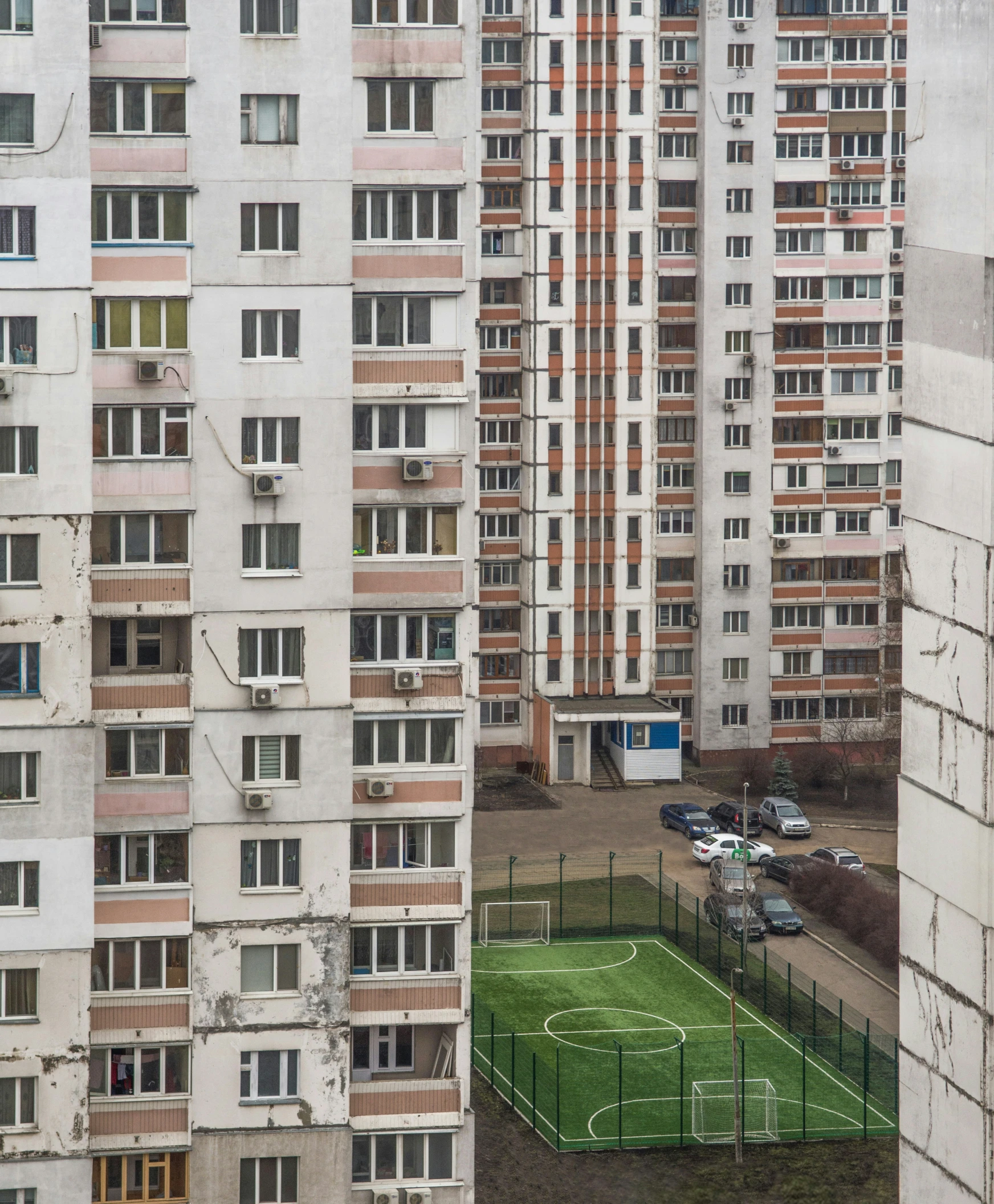 a field in front of tall buildings with soccer fields