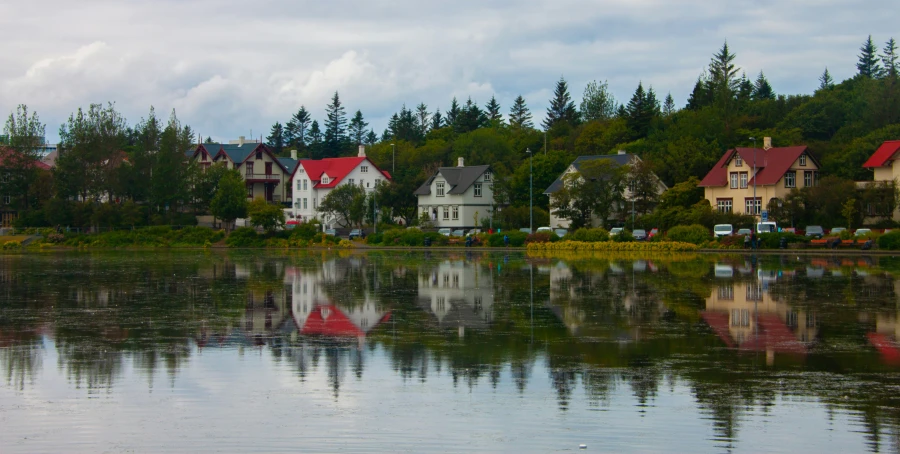 a lake surrounded by trees next to a small town