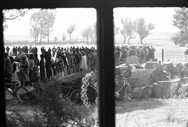 an old pograph of a group of people standing by a wagon