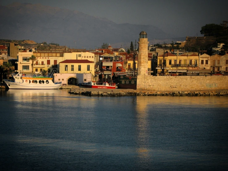 a boat in the water next to a city wall