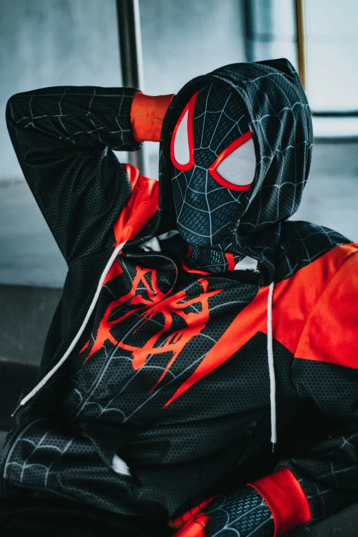 a man wearing spider - man hoodie and sports clothes