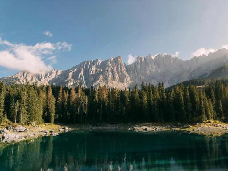 the mountain range is above the blue lake