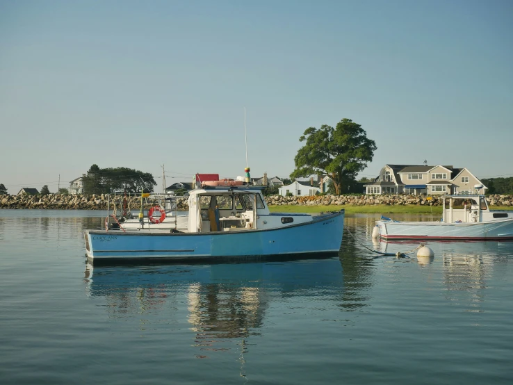 three blue boats parked on water next to houses