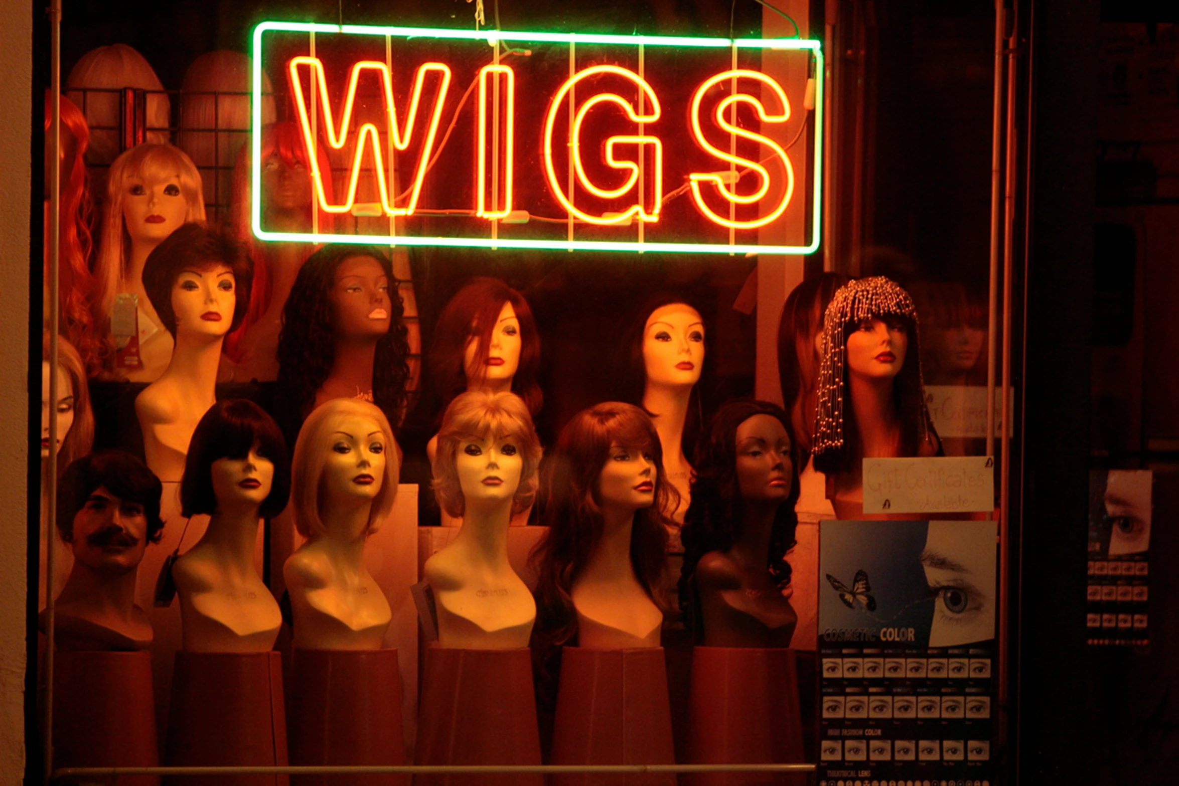 a bunch of mannequins in front of a wigs store