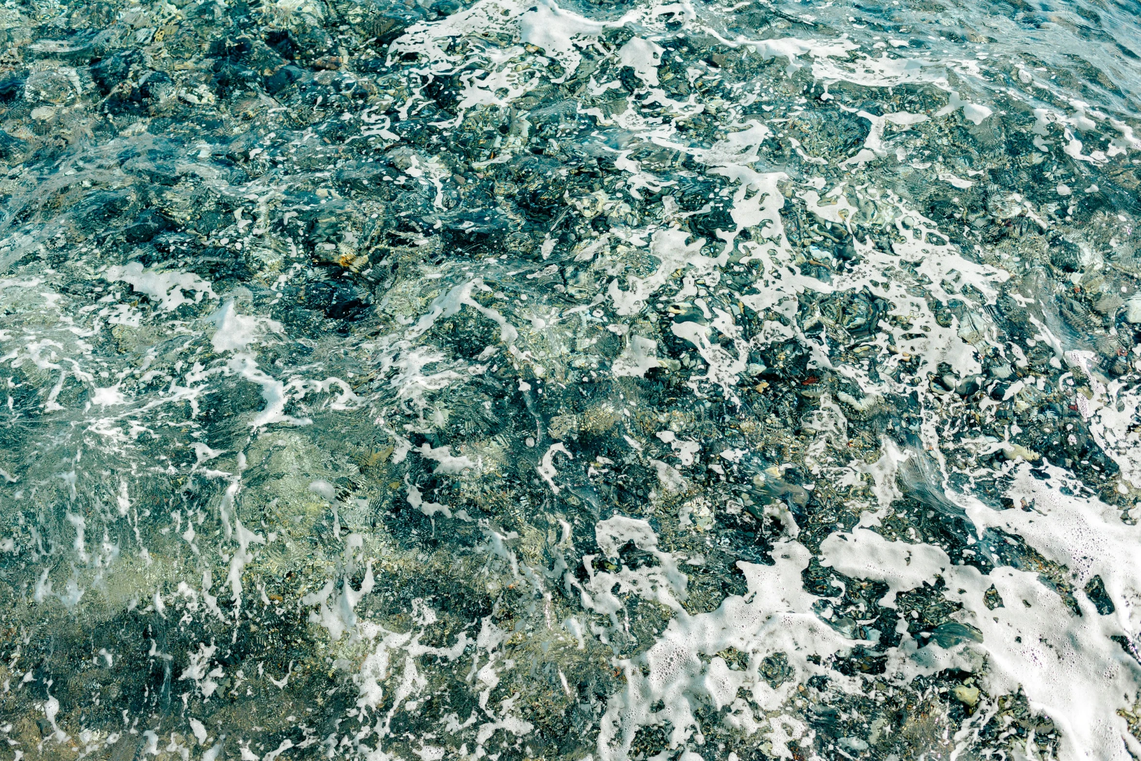 a large amount of sand and water with small white dots