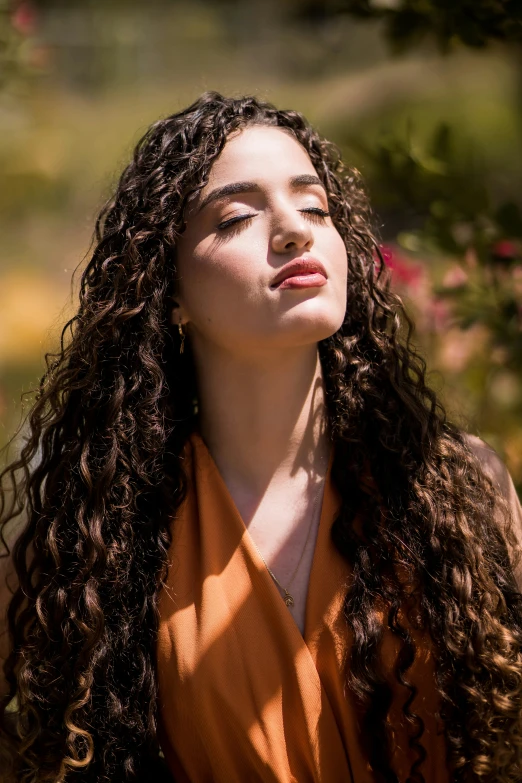 a young woman with long, curly hair stares upward
