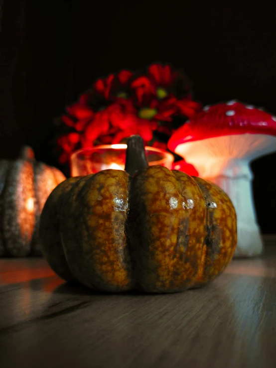 small pumpkins sit on a table with lit candles