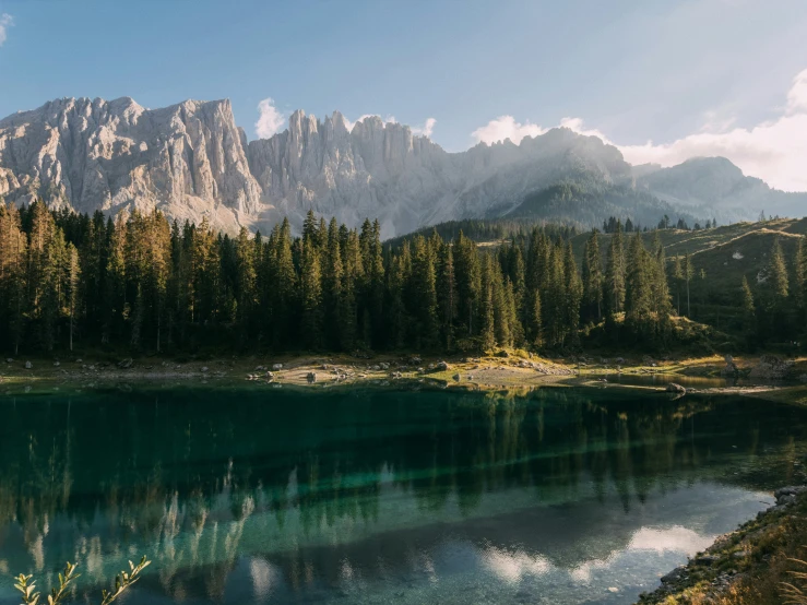 the mountains are reflected in the water and trees