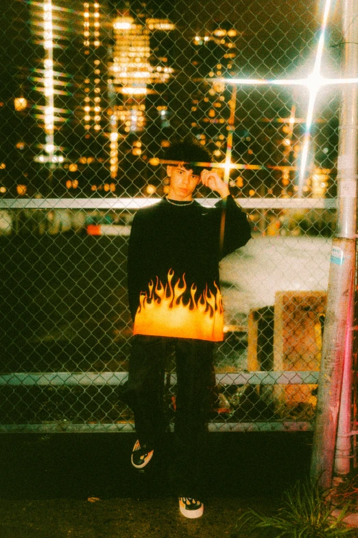 a person holding a bag while standing by a fence