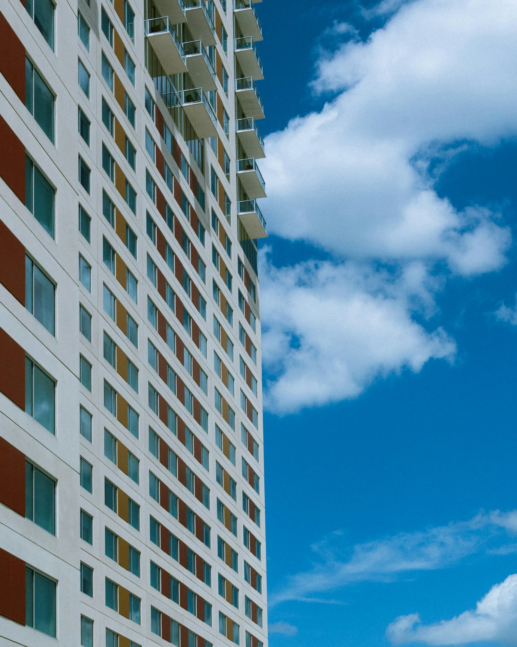 a tall building stands with the sky and clouds in the background