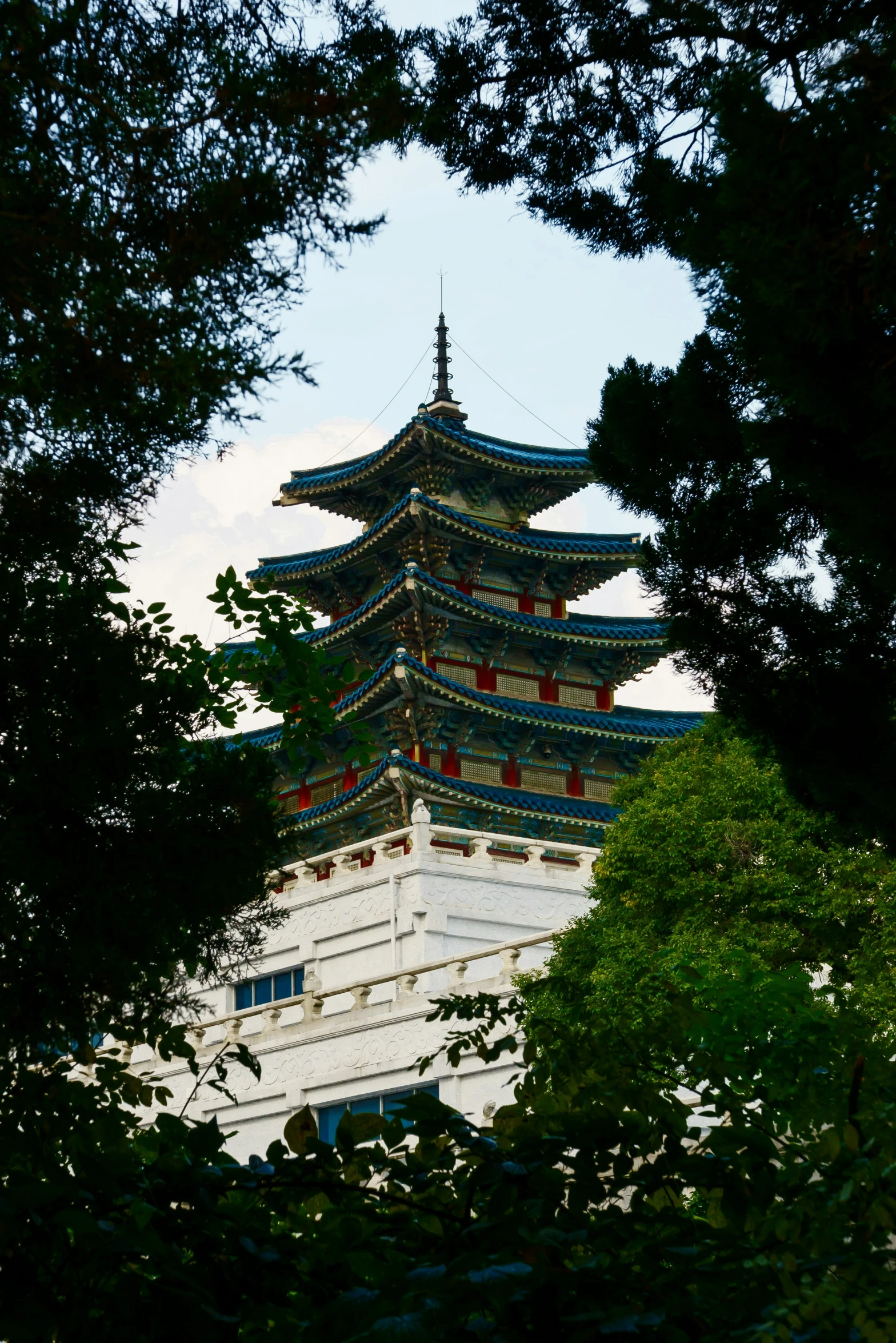 there is a tall pagoda seen through the trees