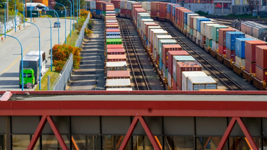 a long train yard with a red track and several train cars